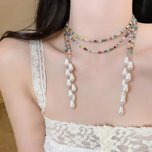 Close-up of a vintage ethnic necklace featuring colorful beads and elegant teardrop pearls