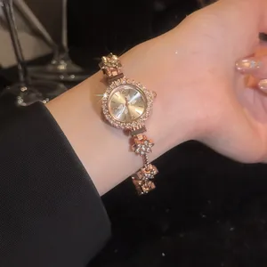Close-up of a vintage rose gold bracelet watch with sparkling rhinestone flower links