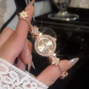 Close-up of a luxury vintage gold flower watch with sparkling rhinestones for women.
