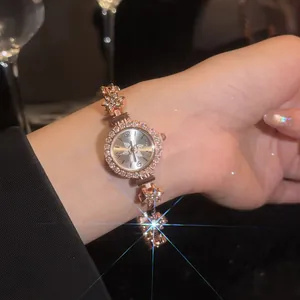 Close-up of vintage gold flower bracelet watch with sparkly rhinestones on wrist