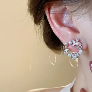 Detailansicht der luxuriösen 18k vergoldeten Stern- und Perlenohrstecker für Damen.