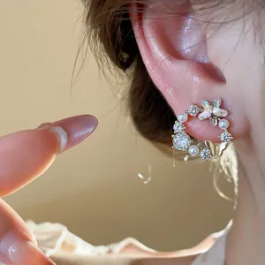 Elegante Nahaufnahme von 18 Karat vergoldeten Ohrringen mit Zirkonstern und Perlen