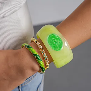 Close-up of vibrant green dopamine-style resin and oil-drip enamel bangles for women