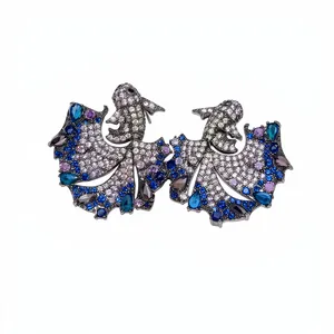 Vintage-style goldfish stud earrings with blue and purple zircons on white background