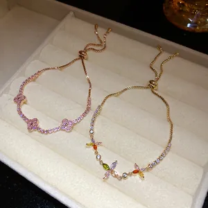 Close-up detail of gold plated zircon bracelets with colorful lucky clover and flowers