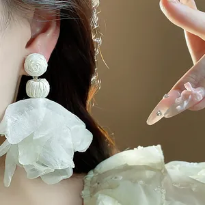 Macro shot showing details of elegant white chiffon flower tassel earrings for women