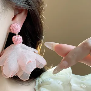 Close-up detail of pink chiffon flower tassel earrings with bohemian design style
