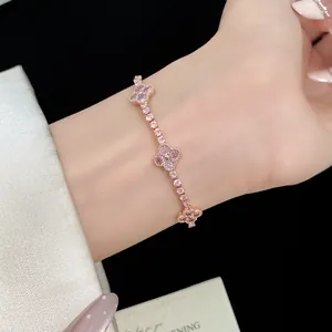 Close-up view of elegant pink zircon four-leaf clover bracelet on a woman's wrist