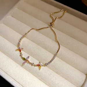 Close-up of a gold adjustable sliding bracelet with colorful zircon clover flowers