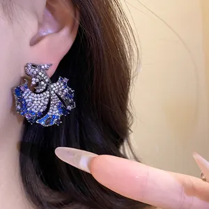 Detailed view of vintage zircon fish stud earrings with blue and purple crystals