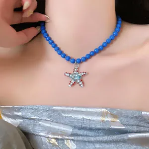 Close-up of a blue beaded choker necklace featuring a colorful starfish pendant detail