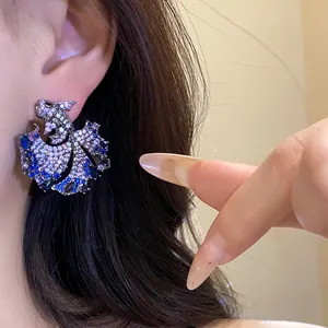 Close-up detail of a vintage koi fish earring featuring sparkling blue and silver zirconia.