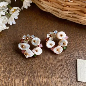 French vintage floral stud earrings with pearls and rhinestones on wood background.