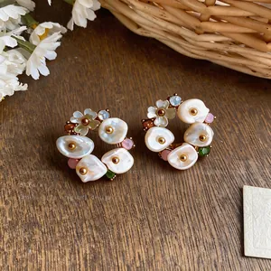 French vintage floral wreath earrings with shell pearls and colorful stones on wood background