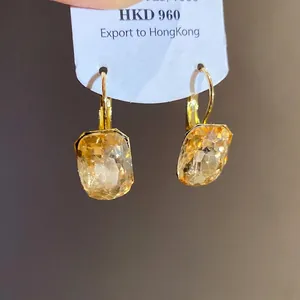 Elegant square champagne crystal drop earrings in gold-tone setting on a display card.
