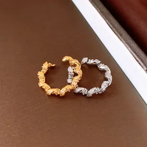 Macro detail of sparkly zircon twisted rings in gold and silver finishes