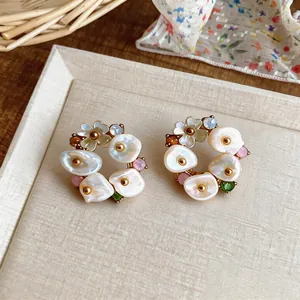 Close-up of vintage flower wreath earrings with pearl petals and colorful gems