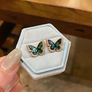 Detailed macro shot of 18k gold plated butterfly stud earrings with sparkling zircons