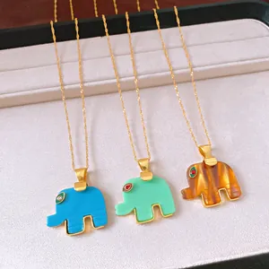 Dettaglio di collane con ciondolo a elefante in acetato blu, verde e color ambra