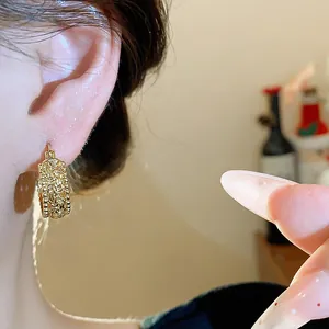 Detailansicht eleganter goldener Creolen mit aufwendigen, feinen Vintage-Prägemustern
