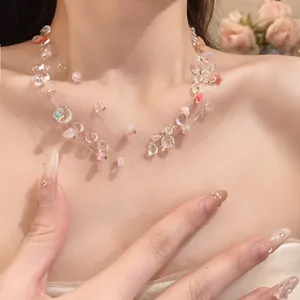 Close-up of a multi-strand clear and pink acrylic beaded necklace on a model's neck.