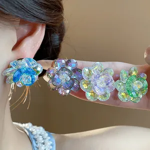 Macro close-up view of sparkling glass flower stud earrings in various iridescent colors.