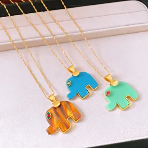 Dettaglio di tre ciondoli a forma di elefante in acetato colorato con catene dorate.