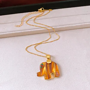 Dettaglio della collana con pendente a elefante ambra vintage e sottile catena dorata