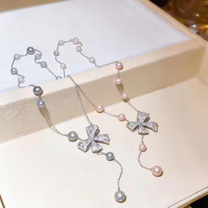 Close-up detail of pearl bow necklace with sparkling zircon pendant.