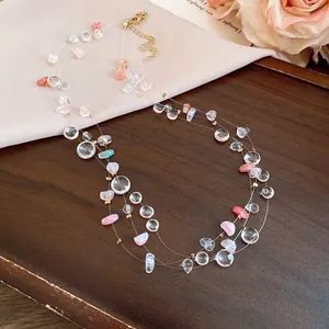 Detailed view of multi-layered acrylic beaded necklace with pink and clear stones