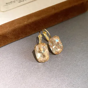Detailed macro view of champagne rectangular crystal drop earrings with gold hooks