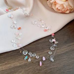 Close-up of elegant multi-layered necklace with irregular pastel acrylic beads and rose decor.
