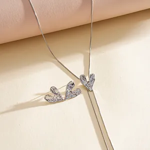 Detail view of a silver-toned lariat necklace with unique wrinkled metallic heart charms.