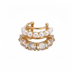 Gold layered ear cuff with white pearls and heart-shaped zircons on a white background.