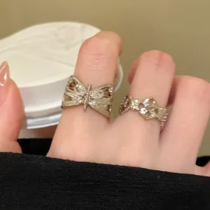 Close-up detail of vintage zircon butterfly and hollow floral adjustable rings on fingers