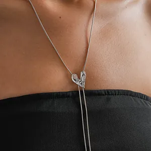 Detail view showing a silver wrinkled heart pendant on a minimalist Y-shaped tassel necklace