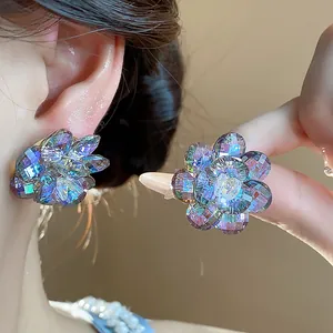Close-up detail of colorful faceted glass flower stud earrings worn on a model ear