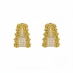 Exquisite gold C-shaped stud earrings featuring sparkling white and yellow diamond pavé