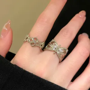 Detailed macro view of a vintage butterfly zircon ring and ornate cross ring on finger