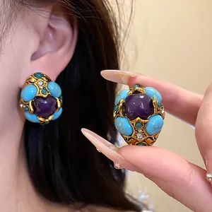Detailed view of vintage court style earrings with turquoise and purple resin stones