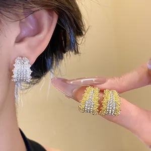 Detailed shot of elegant C-shaped silver needle earrings with shimmering rhinestones