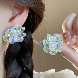 Detailed close-up showing sparkling iridescent glass flower stud earrings worn on ear