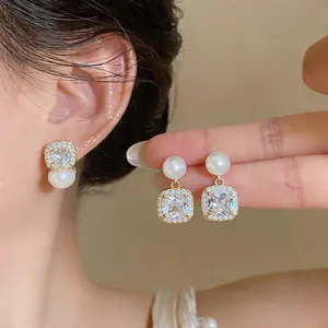 Detail shot of vintage pearl earrings with square crystal studs and gold accents