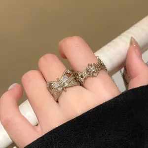 Detail view of vintage style zircon butterfly and floral open rings on finger