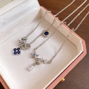 Detailed view of silver-toned necklaces with blue zircon clover and starfish charms