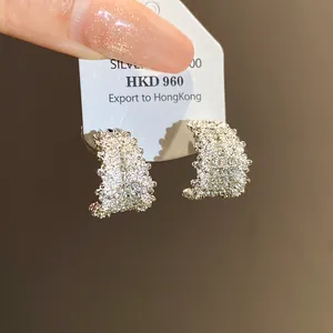 Close-up of sparkling rhinestone C-shaped hoop earrings on display card.