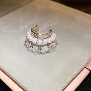 Detailed view of a layered silver ear cuff featuring rows of pearls and sparkling zircons.