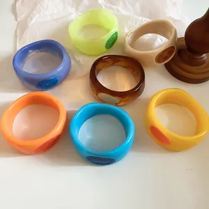 Detailed macro view of colorful resin bangles with unique marbled oil-drip texture.