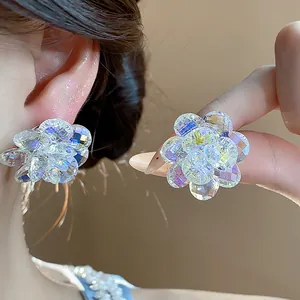 Close-up detail of sparkling glass flower stud earrings with iridescent crystal facets