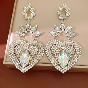 Close-up of vintage heart earrings with sparkling rhinestones and iridescent crystals.